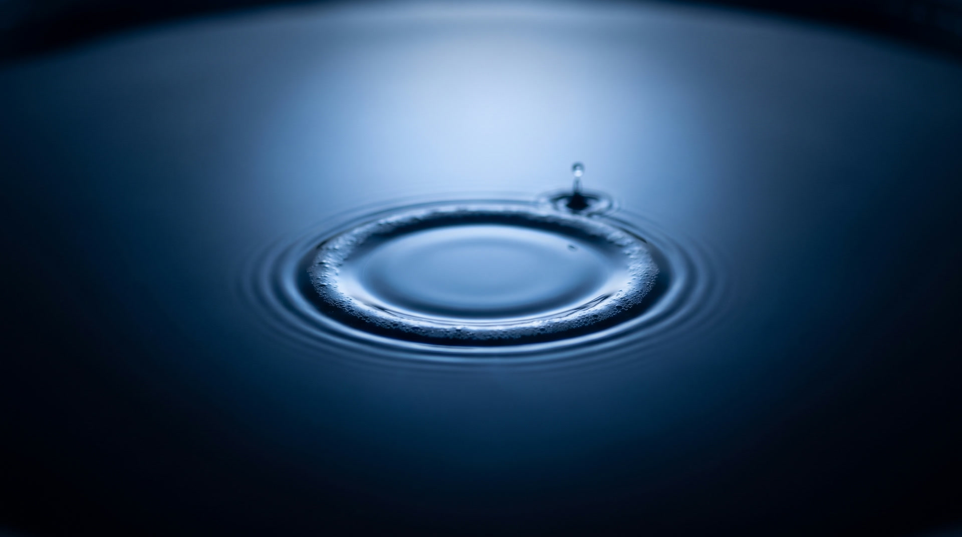 A ring caught halfway out with a droplet rebounding behind it